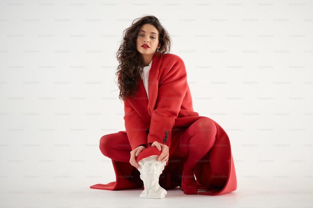 a woman in a red suit kneeling down