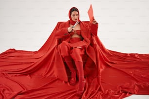 a woman in a red outfit holding a pair of scissors