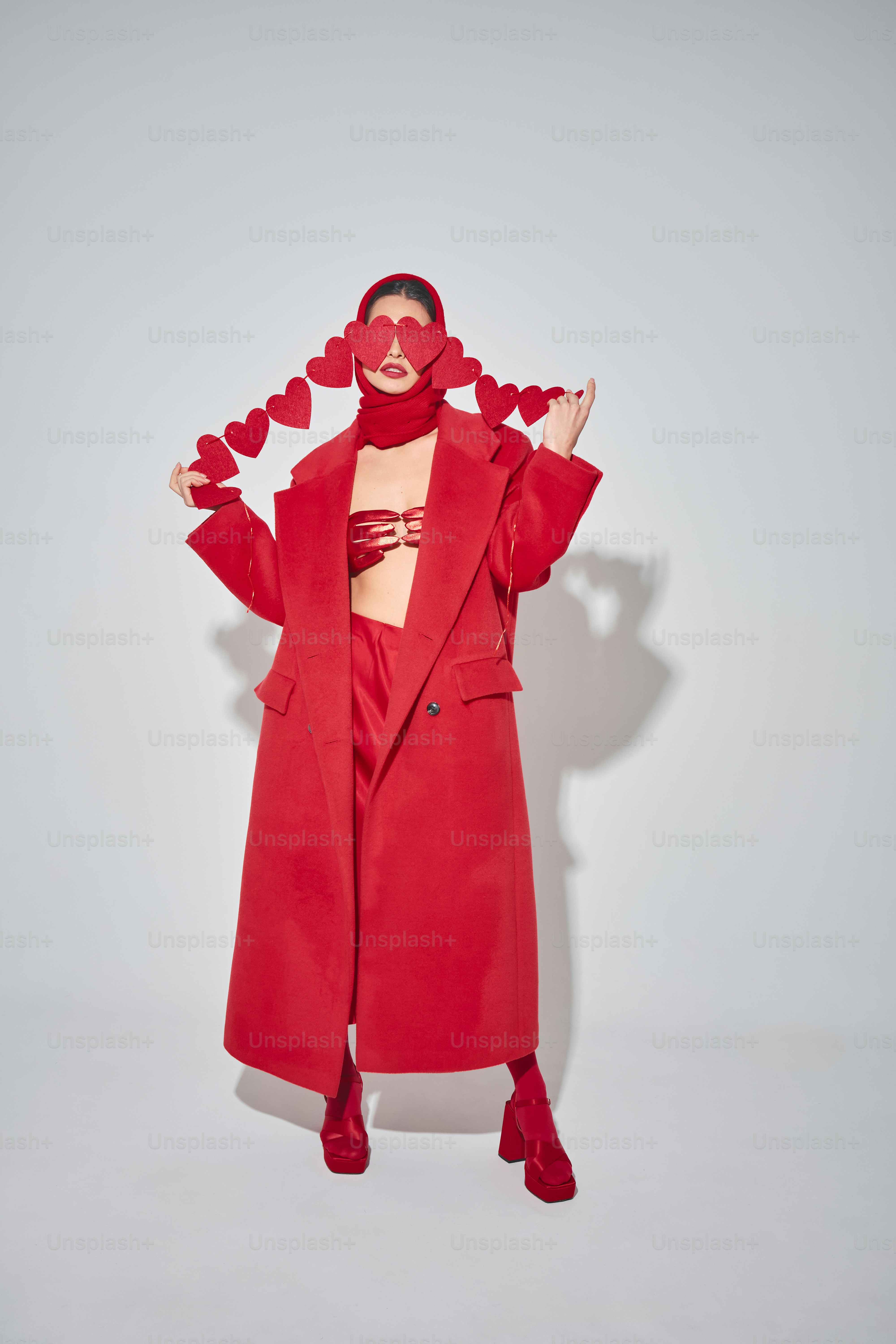 a woman in a red coat with hearts on her head