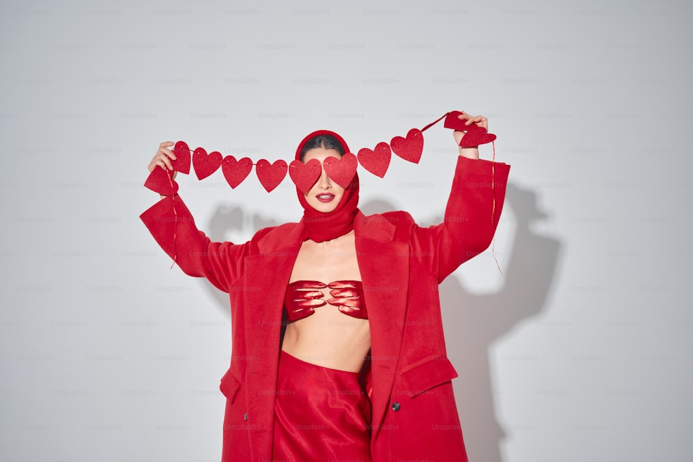 eine Frau in einem roten Outfit mit Herzen auf dem Kopf