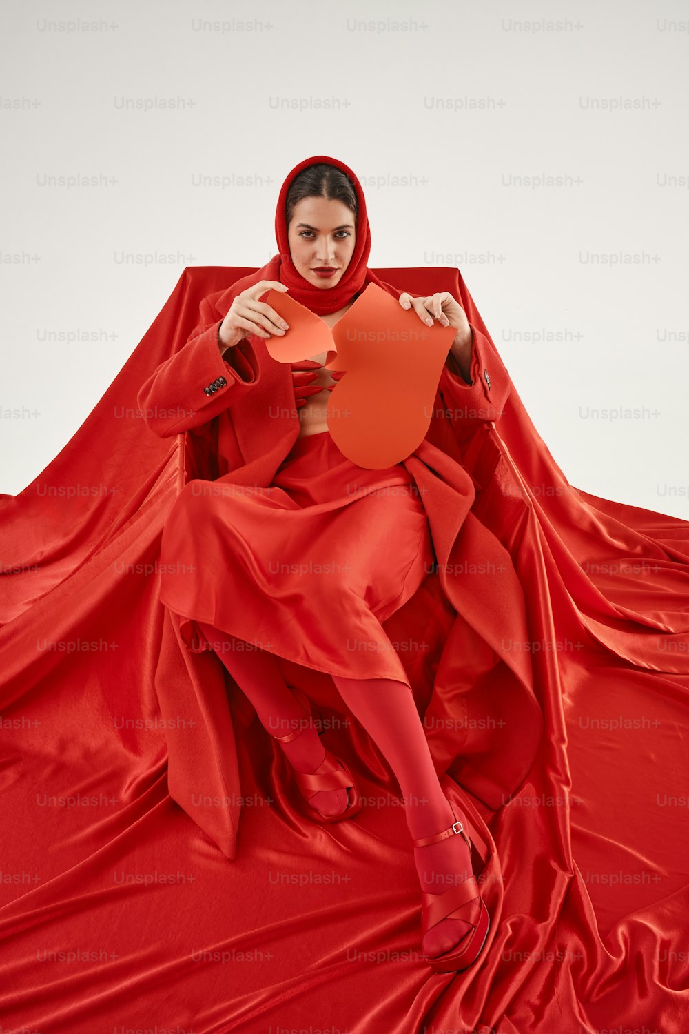 a woman sitting on top of a red sheet