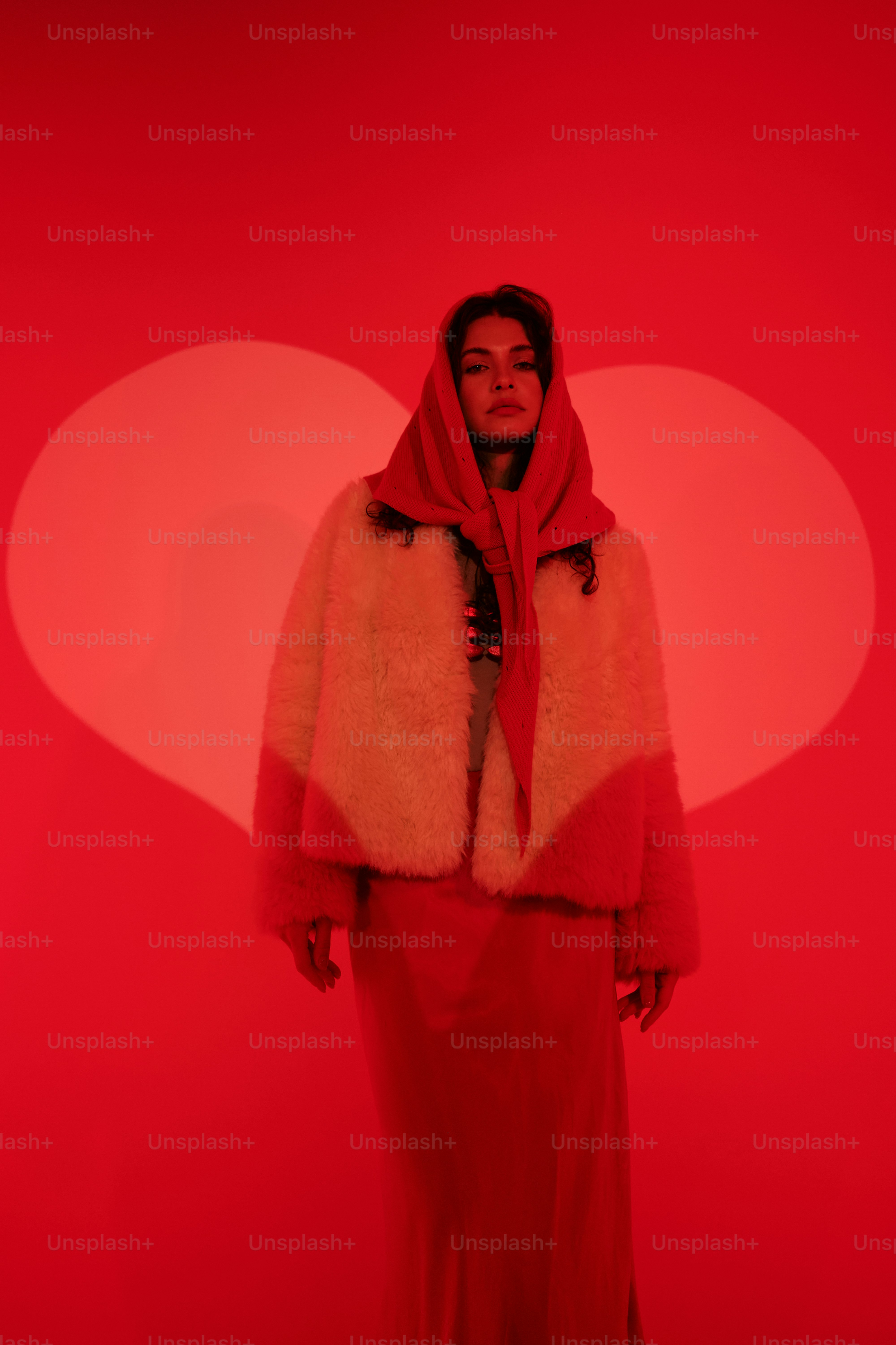 a woman standing in front of a red background