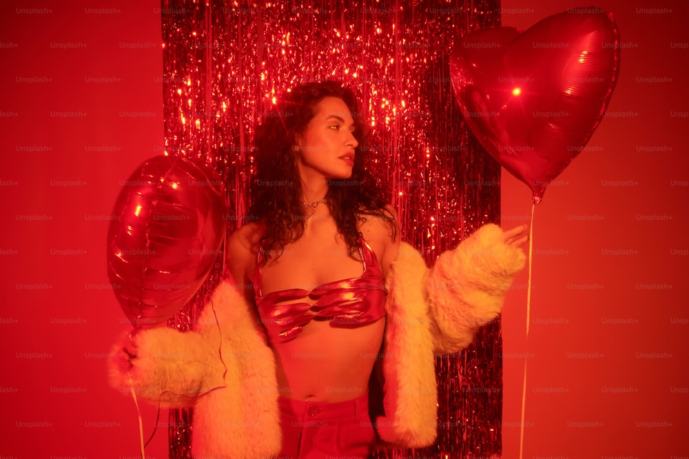 a woman in a red outfit holding balloons