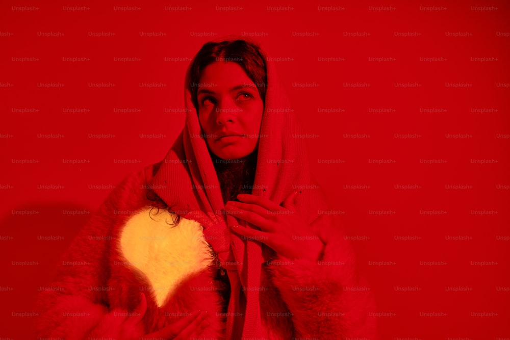 a woman in a fur coat holding a heart
