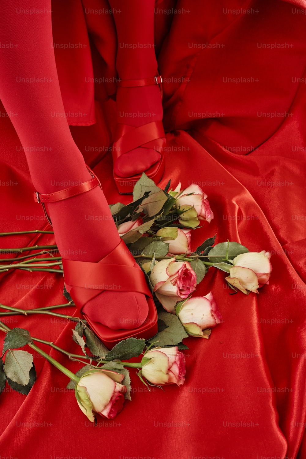 una donna in un vestito rosso con rose sul pavimento