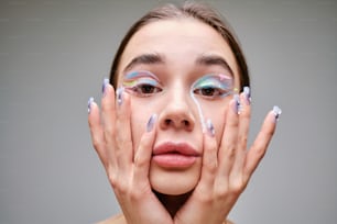 a woman with painted nails holding her hands to her face
