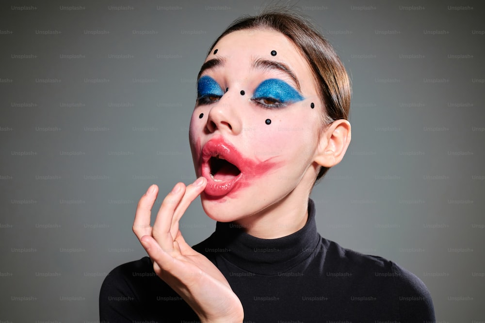 Uma mulher com maquiagem azul e vermelha está fazendo cara