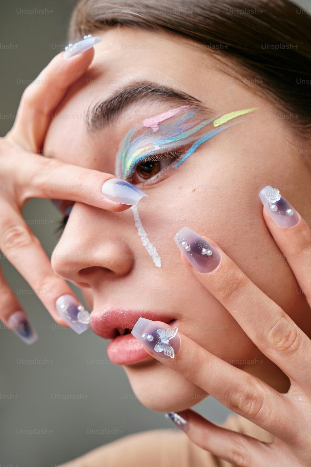 una donna con nail art colorata sul suo viso