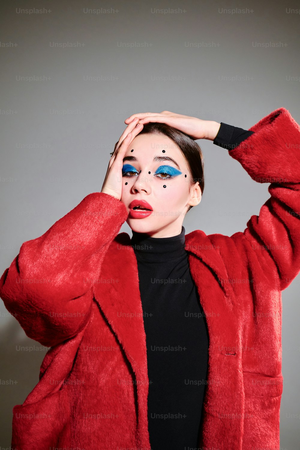 a woman in a red coat with blue makeup