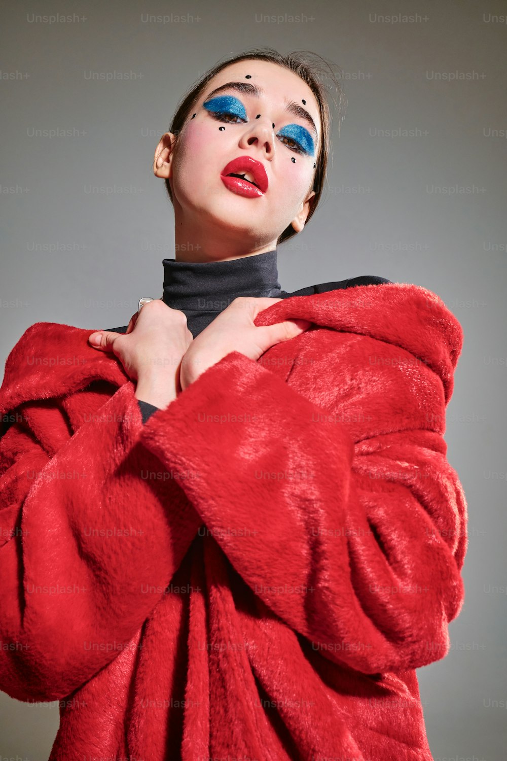 una donna in un cappotto rosso con gli occhi azzurri