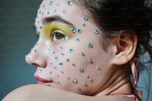 a woman with her face painted with silver dots