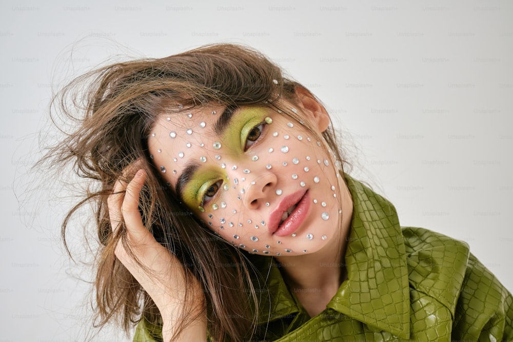 a woman with a green shirt and white dots on her face