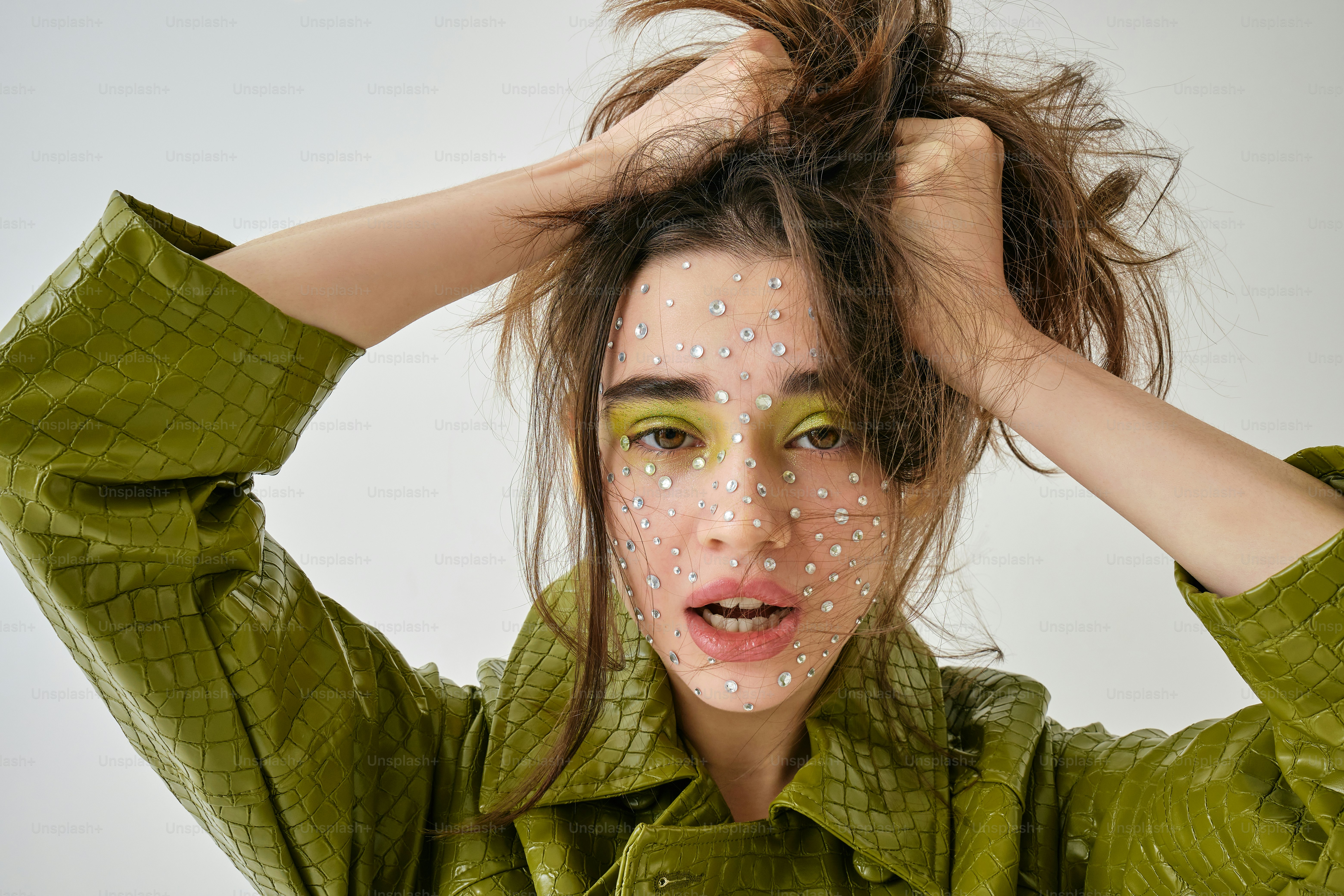 eine Frau mit grünem Make-up und grüner Jacke