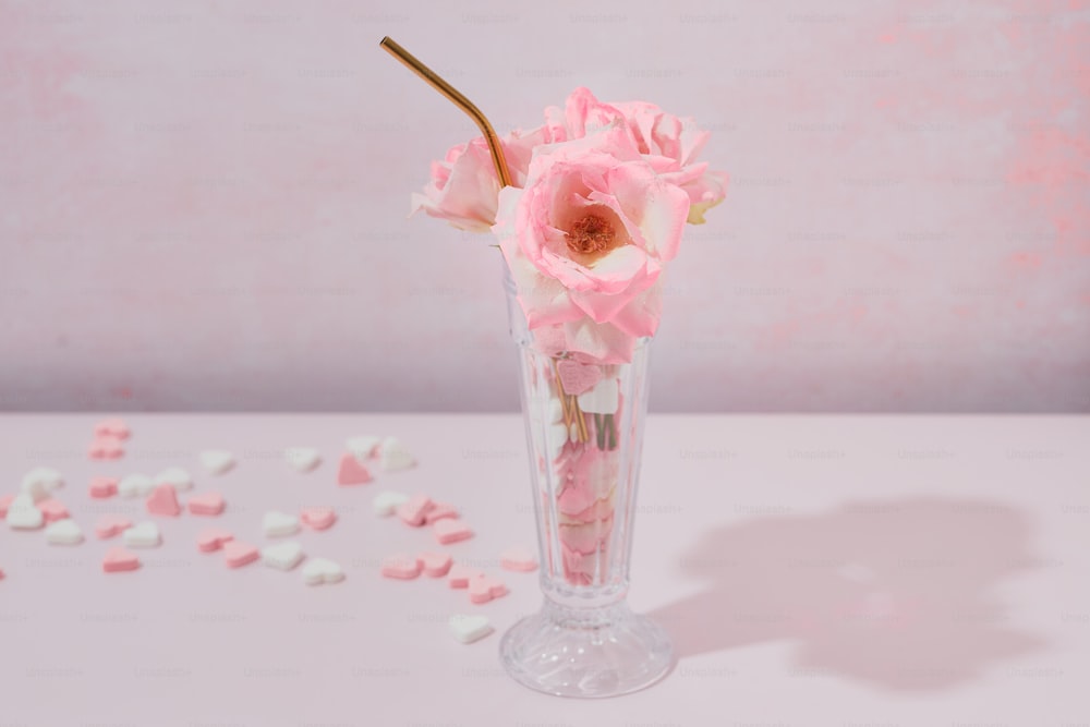 un vase rempli de fleurs roses sur le dessus d’une table
