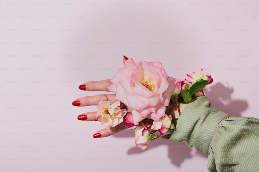 die Hand einer Frau, die einen Blumenstrauß hält