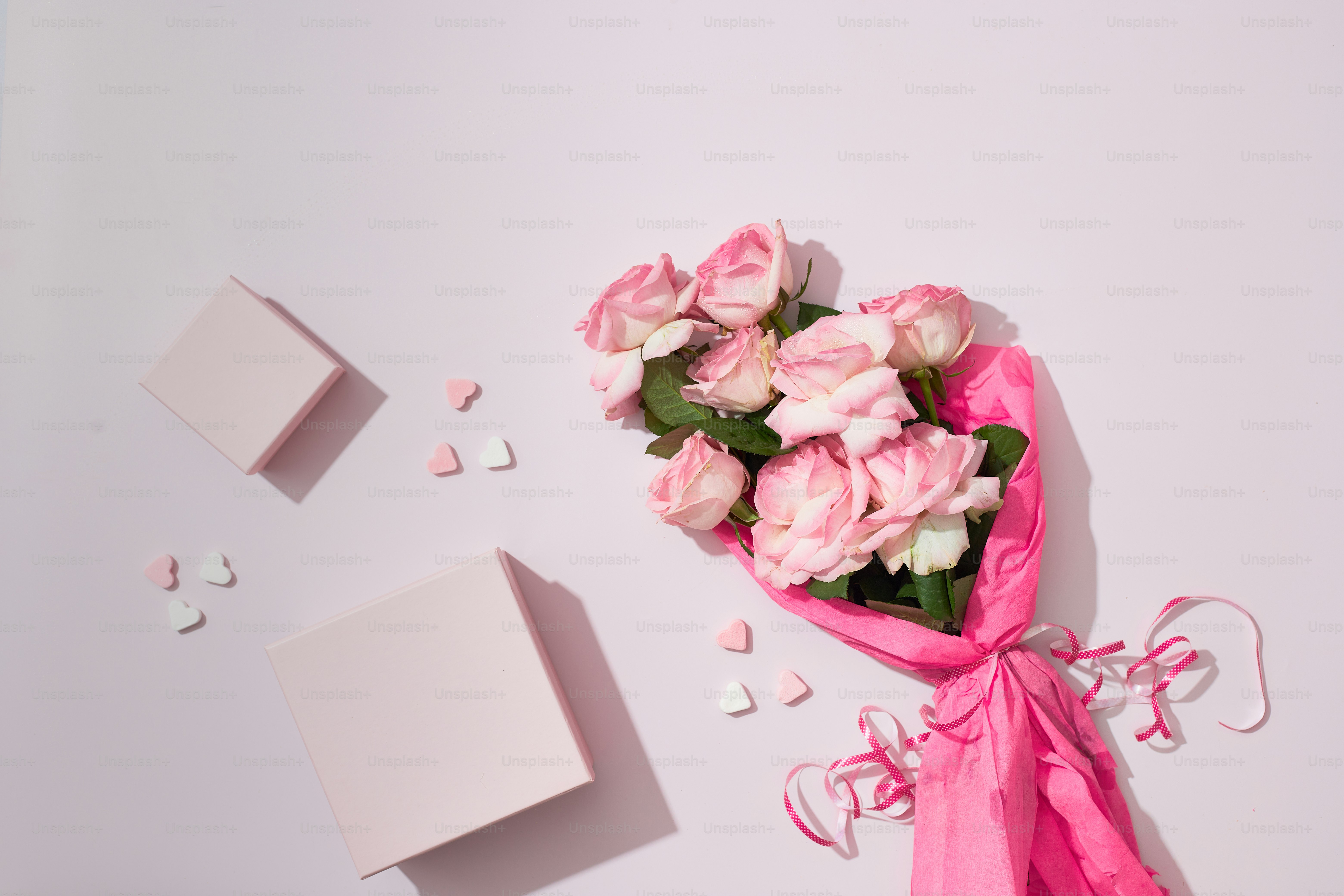 a bouquet of pink roses next to a white box