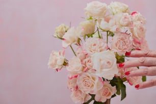 a woman holding a bouquet of pink and white roses