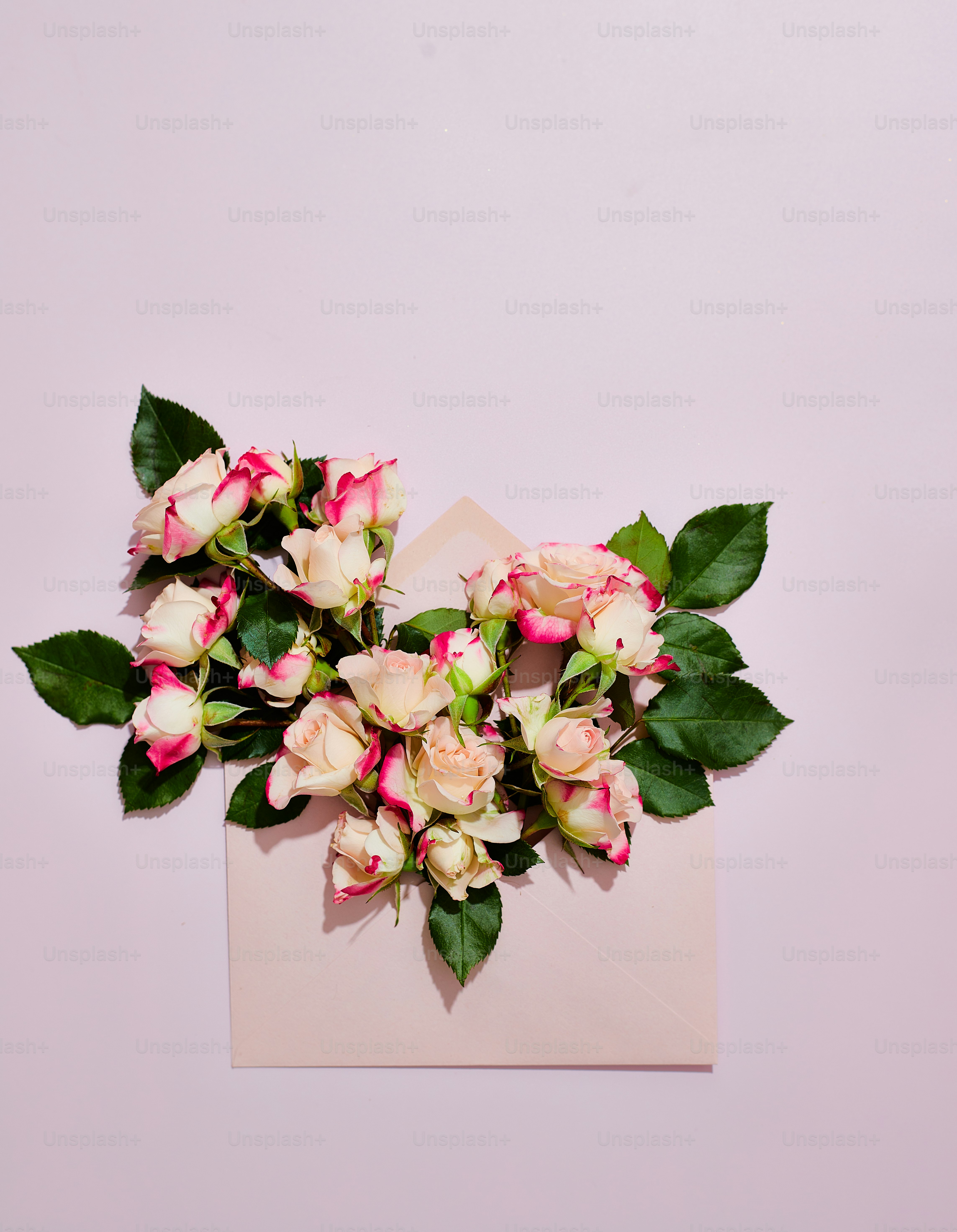 a bouquet of pink and white flowers sitting on top of a piece of paper