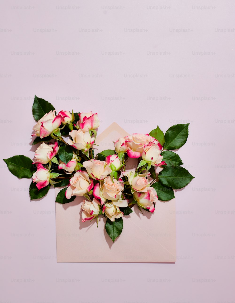 a bouquet of pink and white flowers sitting on top of a piece of paper