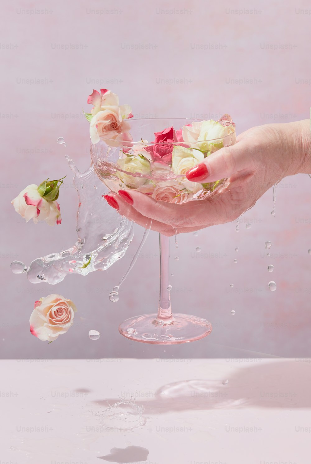 a person holding a wine glass filled with flowers