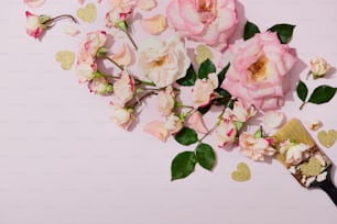 Rosas cor-de-rosa e corações dourados em um fundo rosa