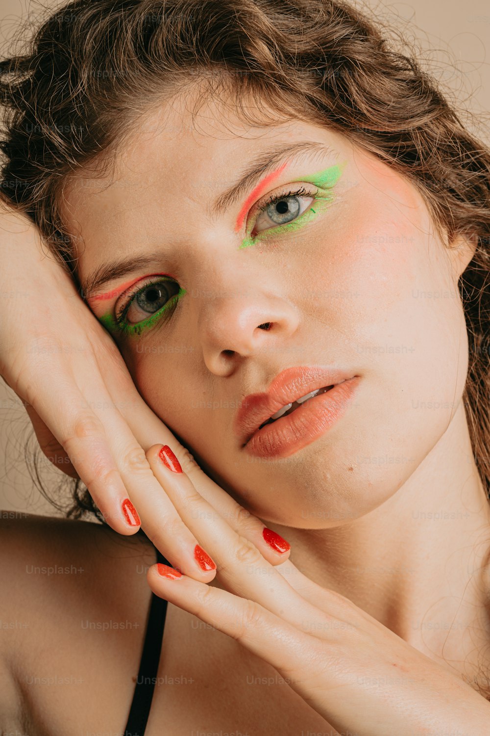 a woman with green and red makeup posing for a picture