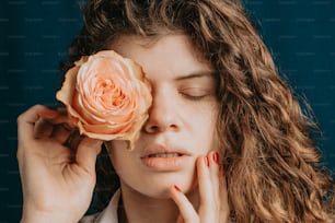 a woman with her eyes closed holding a rose