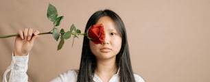 a woman holding a rose up to her face