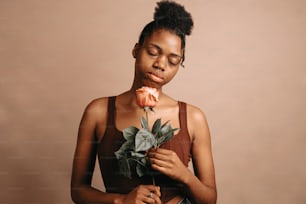 una mujer sosteniendo una rosa en su mano derecha