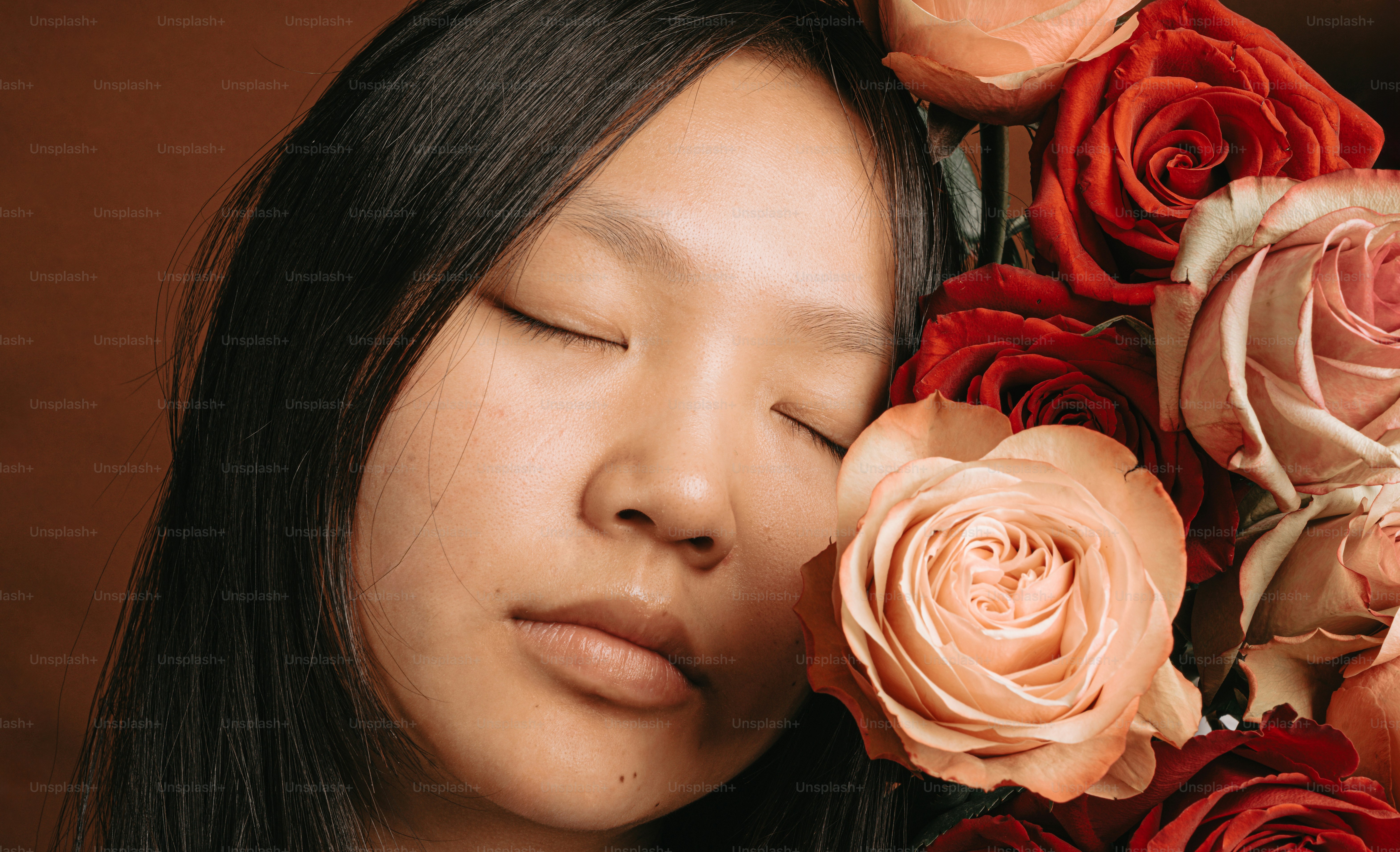 a close up of a person with flowers in the background