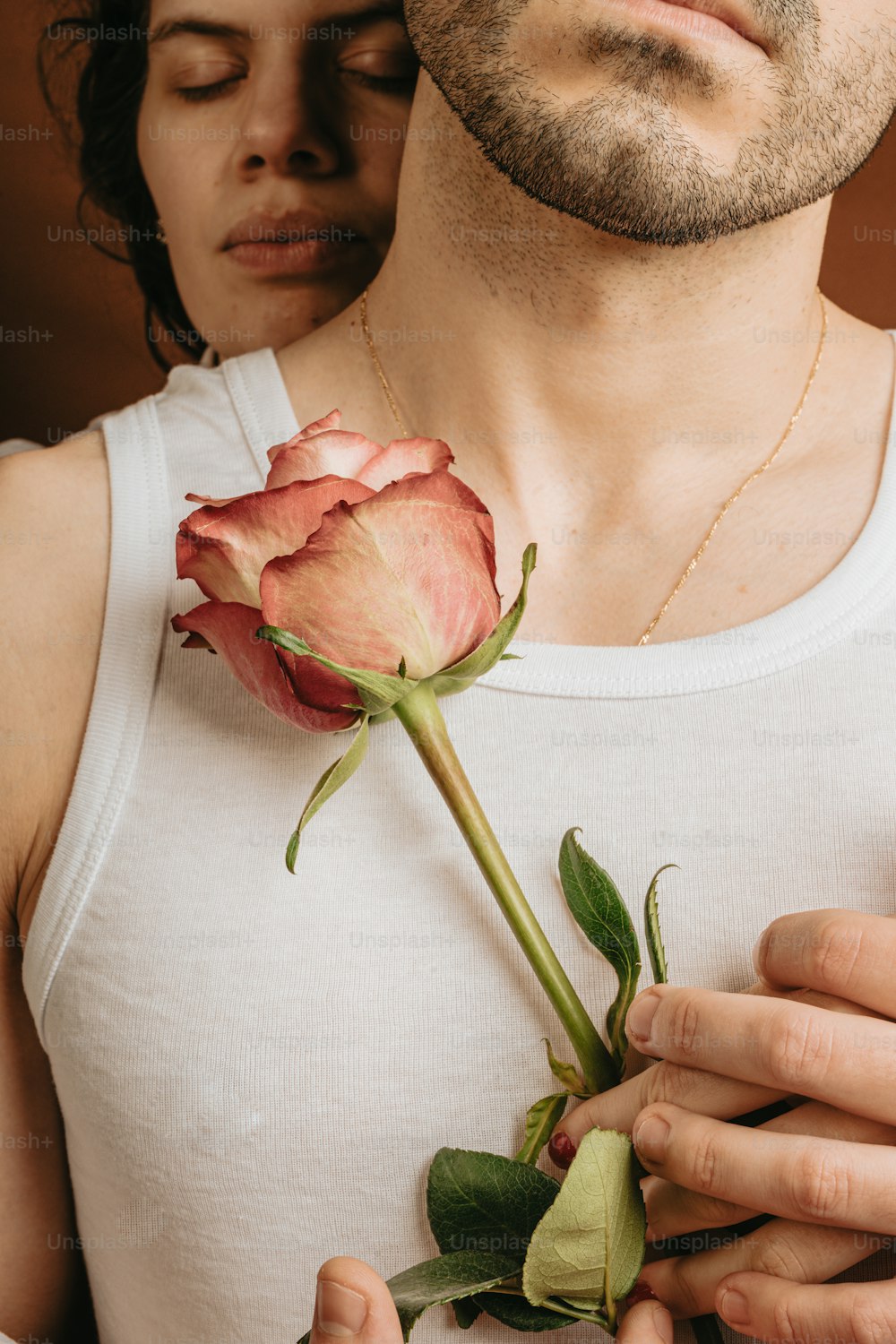 a man is holding a rose in his hands