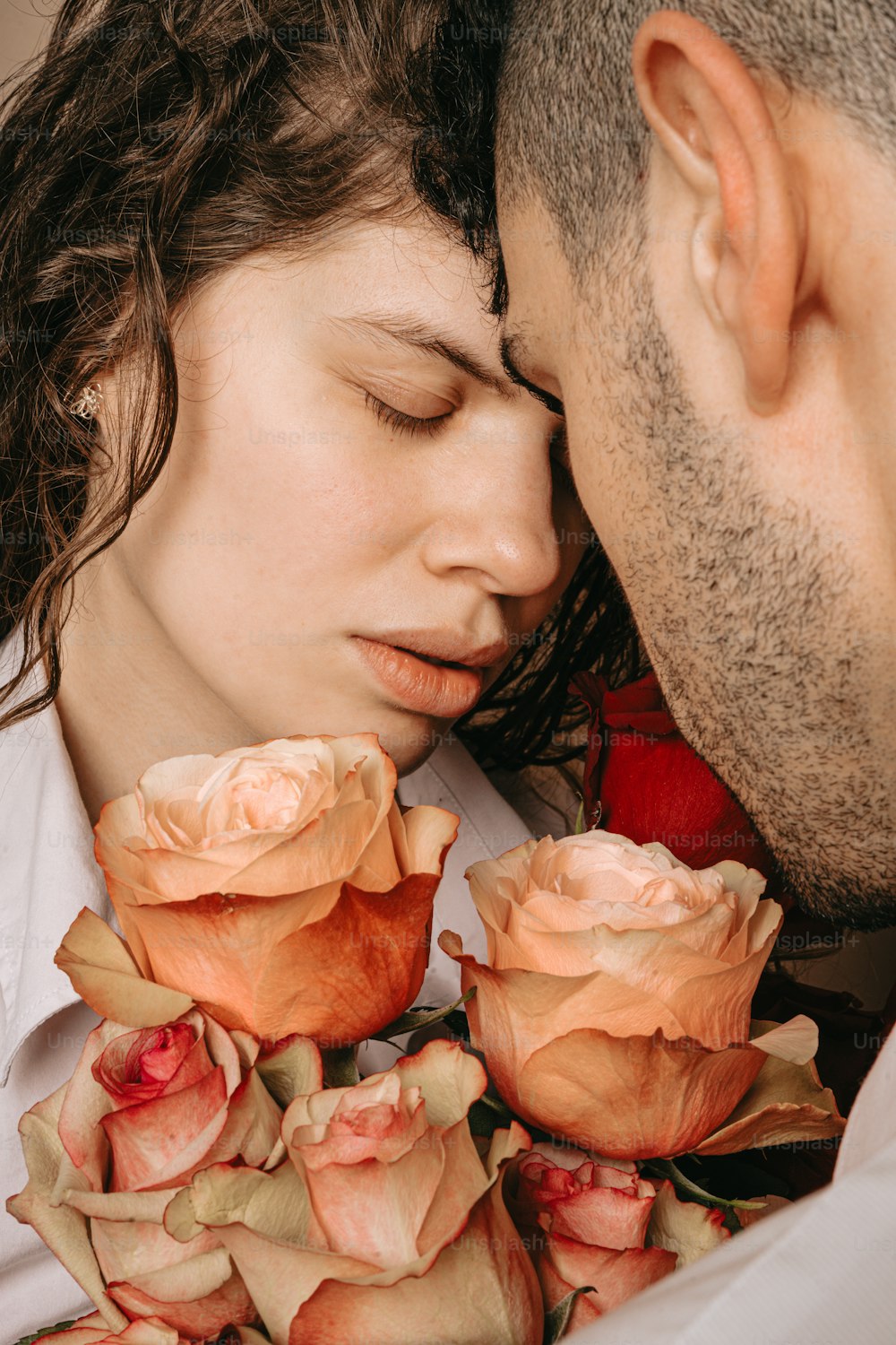 a man kissing a woman with roses in her lap