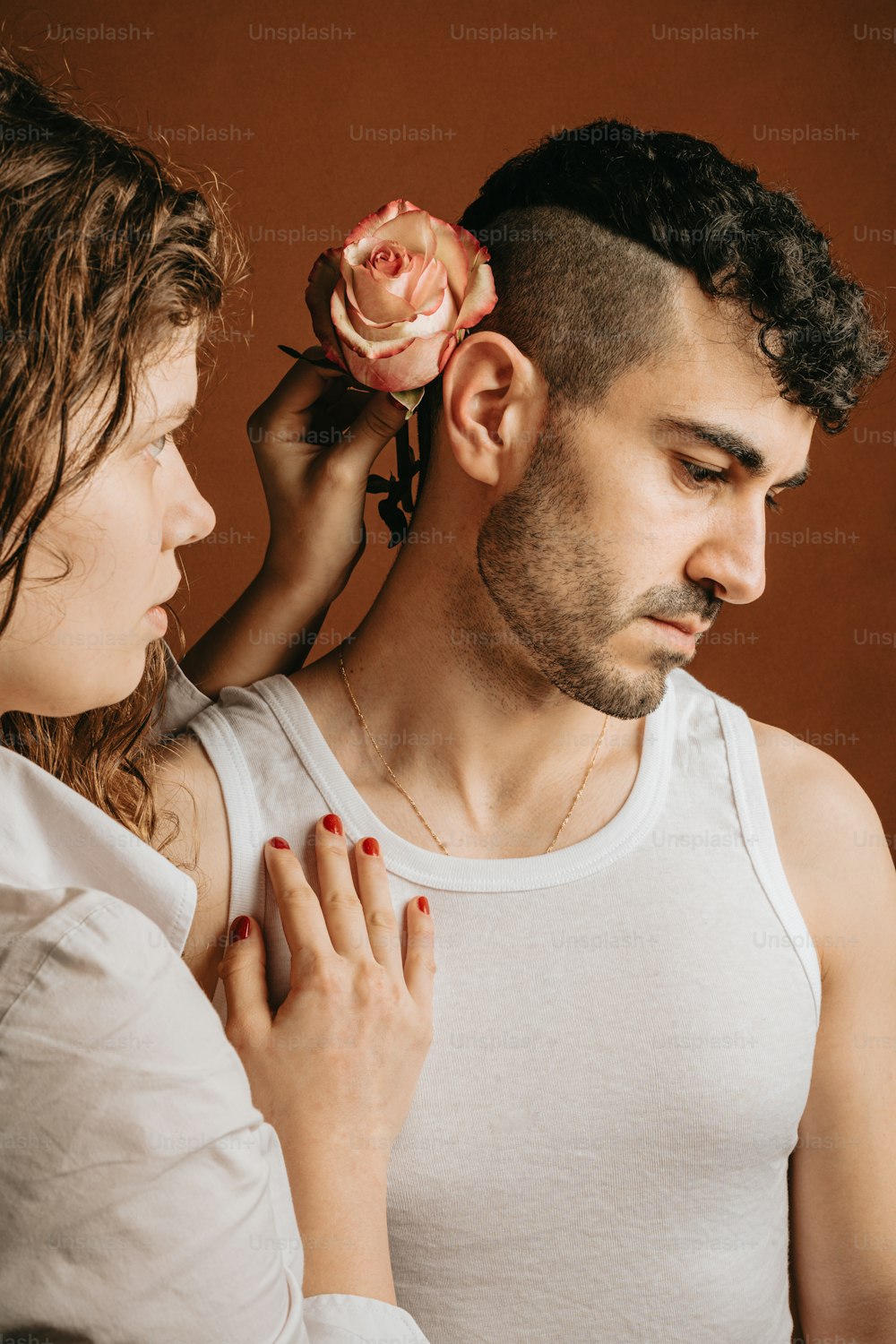 a man putting a flower on a woman's head