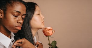 a man putting a flower on a woman's neck