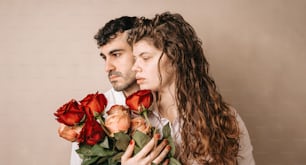 a man and a woman holding roses in their hands