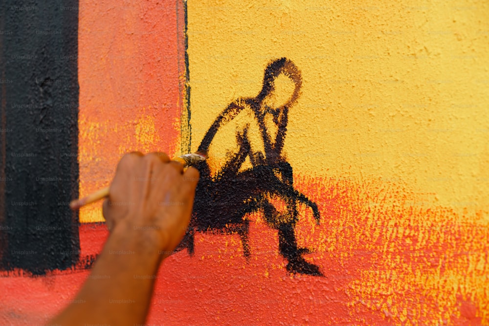Una persona sta dipingendo un quadro su un muro