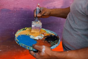 Un uomo sta dipingendo un muro con un pennello