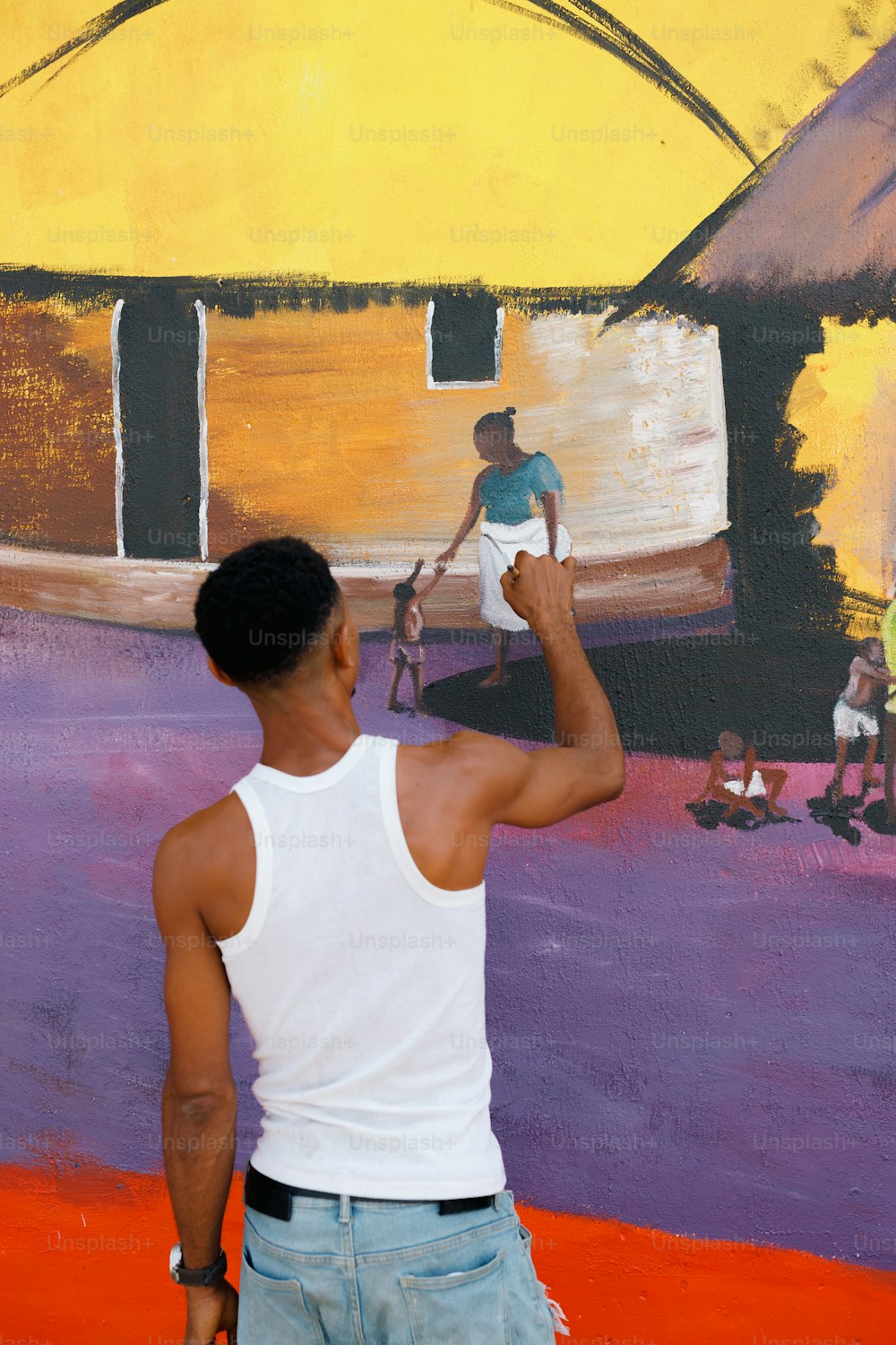 Ein Mann malt ein Wandgemälde an eine Wand