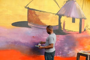 a man painting a mural on a wall