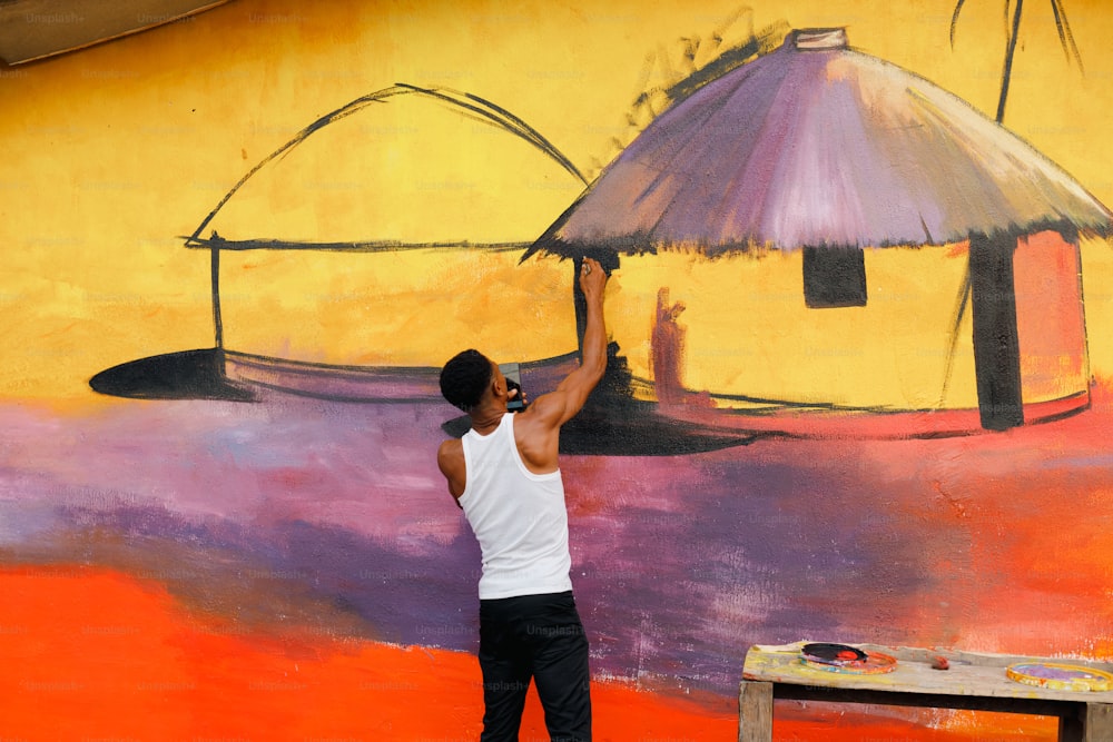 un uomo che dipinge un murale su un muro