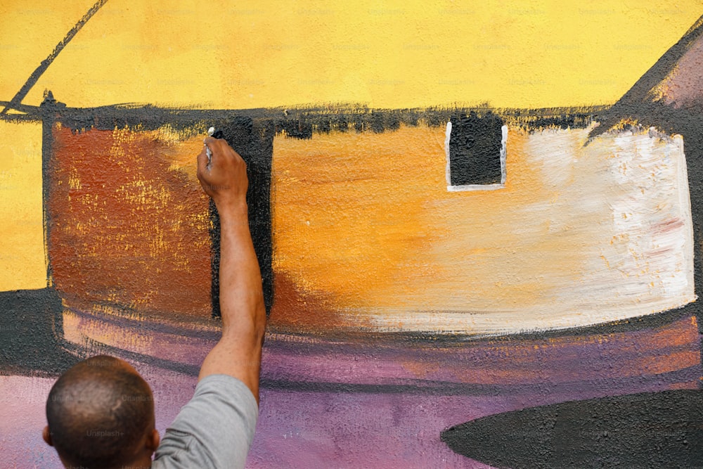 a man is painting a wall with a brush