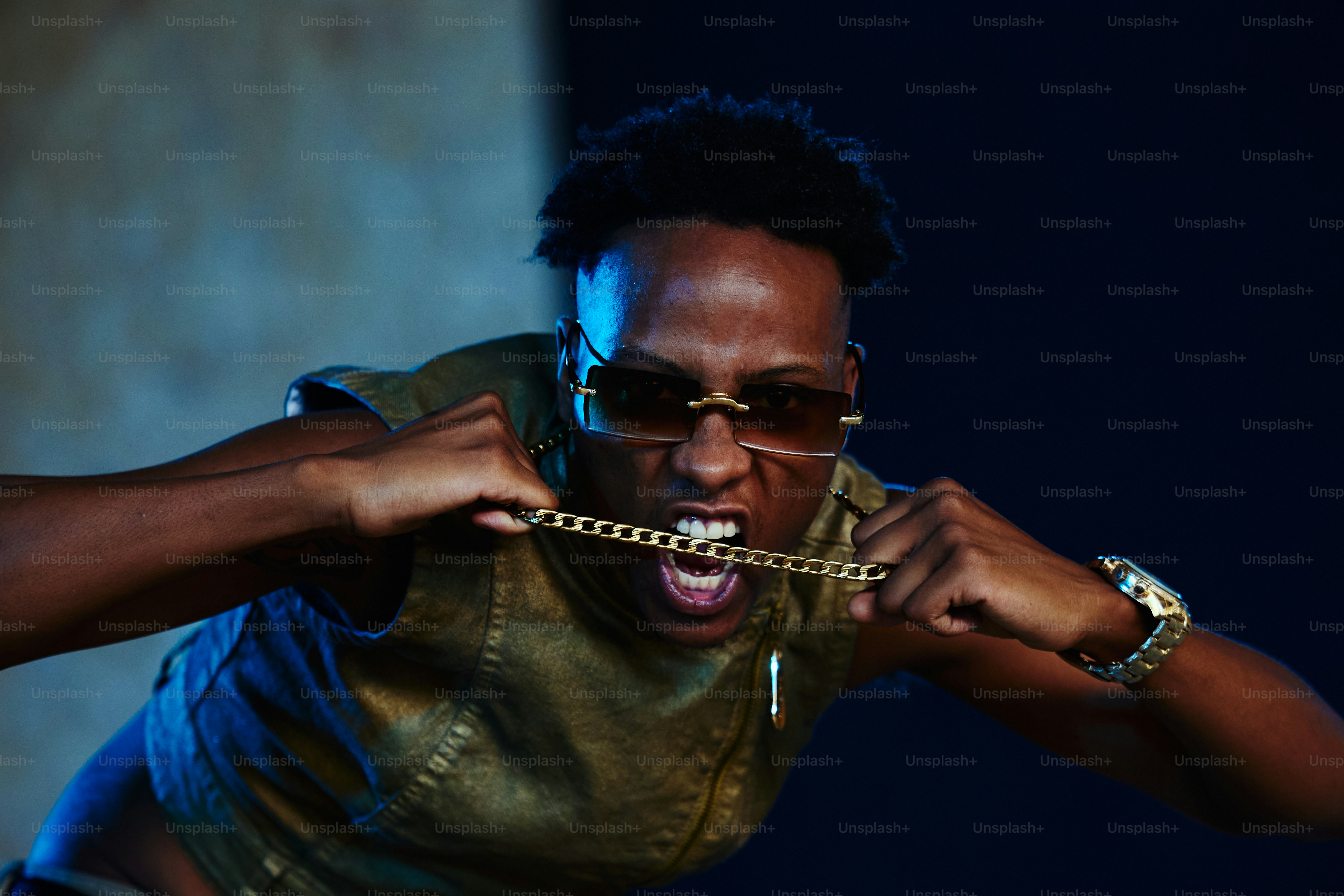 a man wearing sunglasses and a chain around his neck