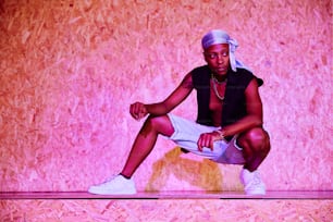 a man sitting on top of a wooden floor