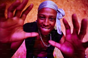 a woman with a bandana on her head and hands in the air