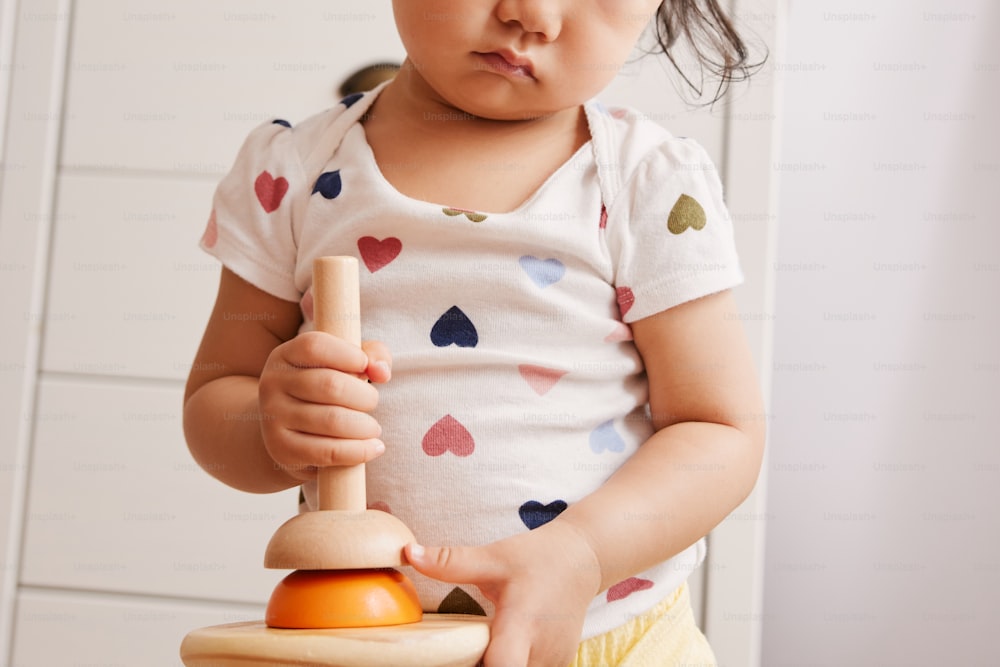 a little girl playing with a wooden toy
