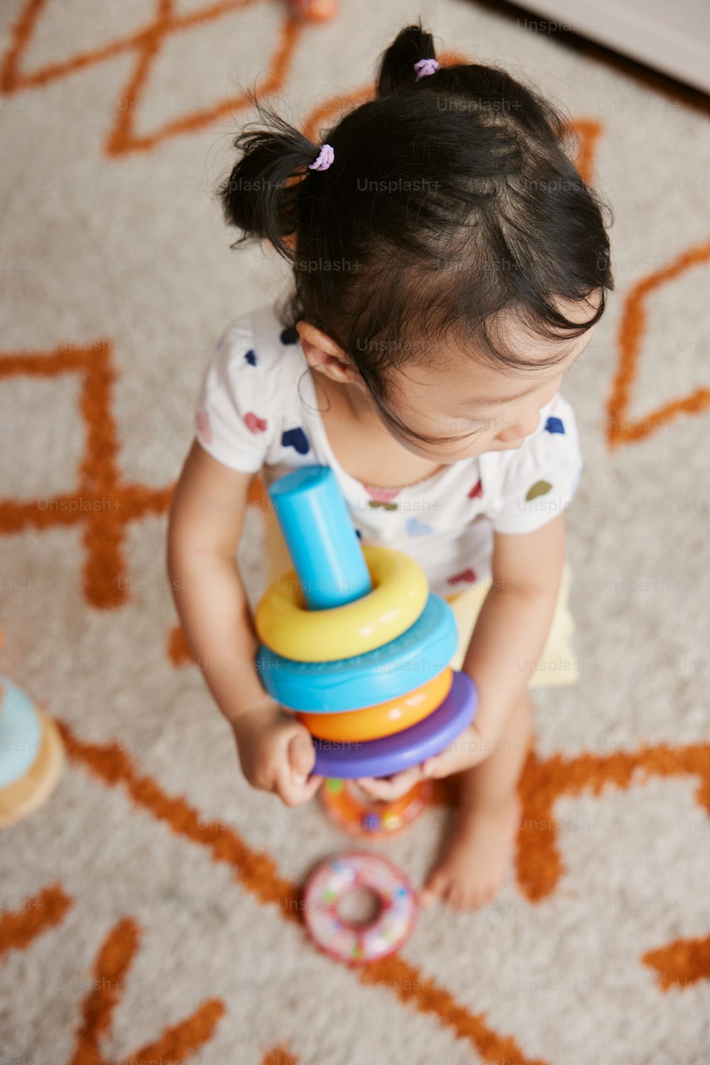 a little girl playing with a stacking toy