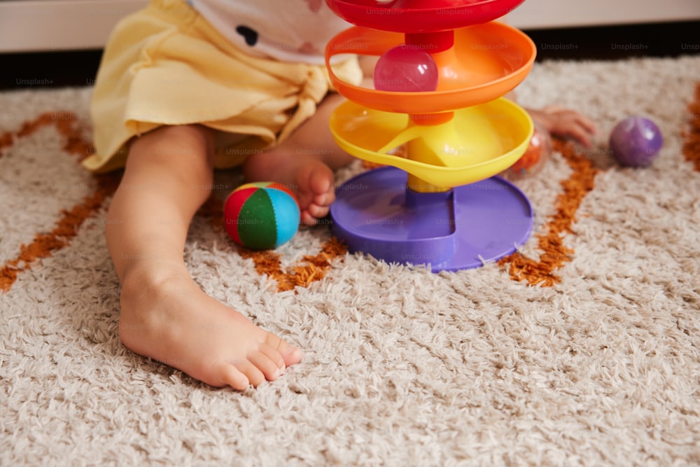 ein Kleinkind, das mit einem Stapelspielzeug auf dem Boden spielt