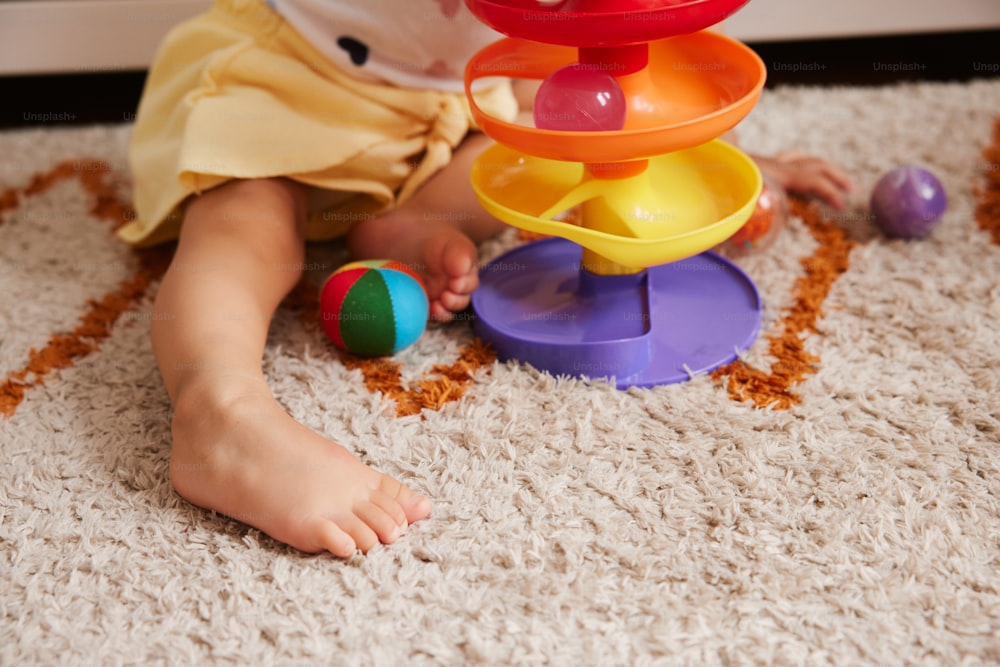 a toddler playing with a stacking toy on the floor