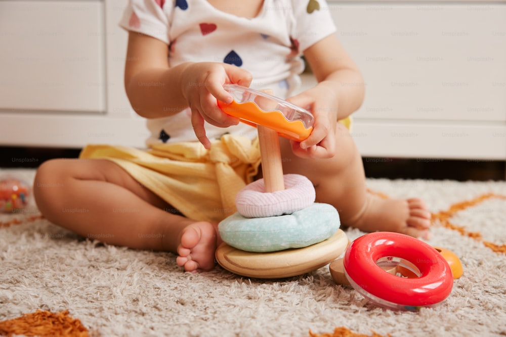 un bébé assis sur le sol en train de jouer avec un jouet