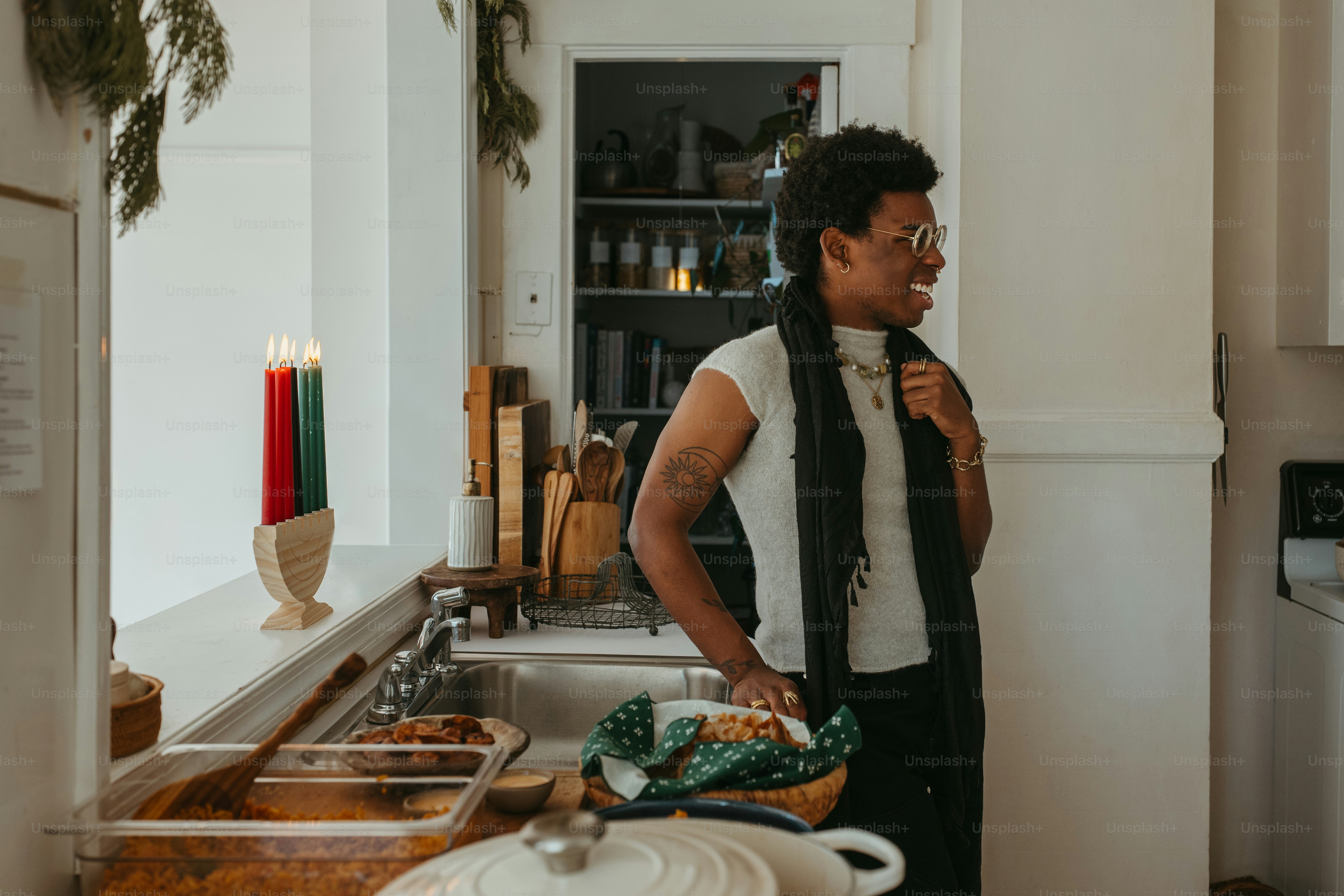 a man standing in a kitchen next to a sink